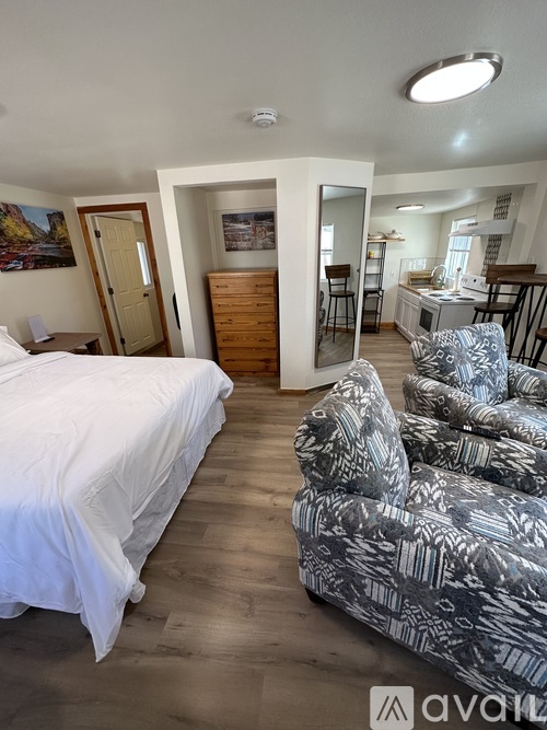 A bedroom with a white bed and a patterned chair.