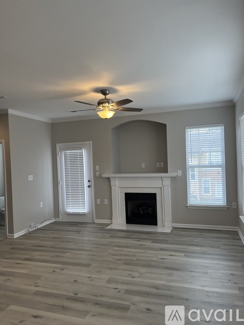 A living room with a fireplace and a ceiling fan.