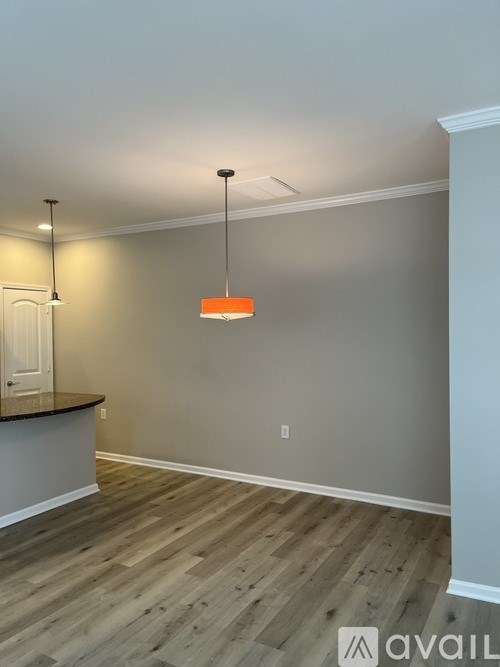 A room with wooden flooring and a white door.