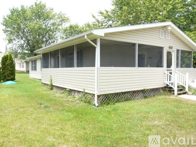 A mobile home with a white exterior and a porch.