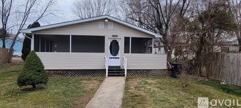 A small house with a white door and a porch.