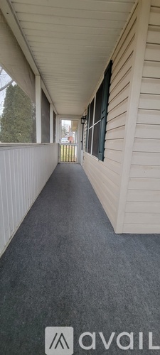 A long, narrow hallway with a carpeted floor and white walls.
