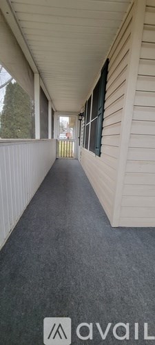 A long, narrow hallway with a carpeted floor and white walls.