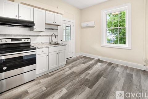 A kitchen with a stove top oven and a window.