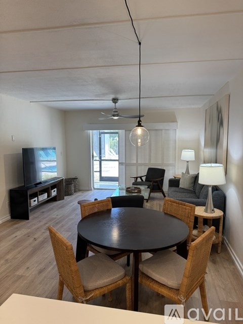 A living room with a black table and chairs.