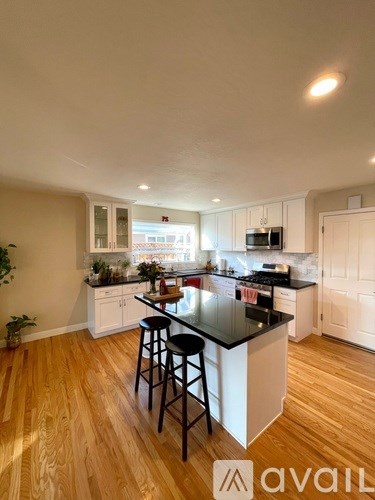 A kitchen with a black countertop and white cabinets.