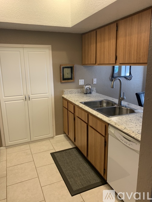 A kitchen with wooden cabinets and a white dishwasher.