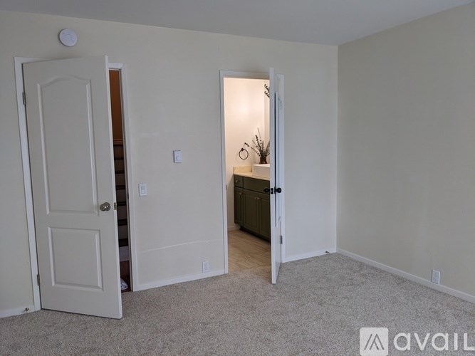 A room with a carpeted floor and a doorway leading to another room.