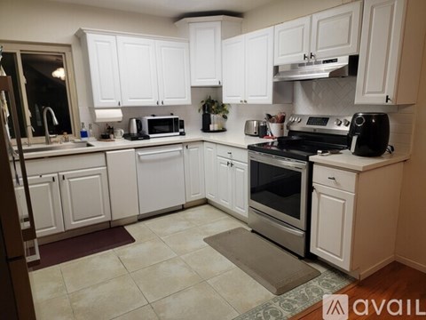 A kitchen with white cabinets and appliances.