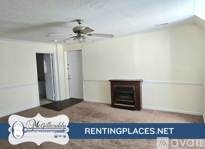 A room with a carpeted floor and a ceiling fan.