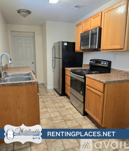 A kitchen with a refrigerator, oven, microwave, sink and cabinets.