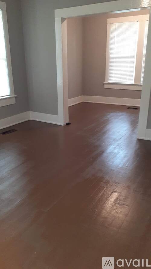 A room with wooden flooring and a window.