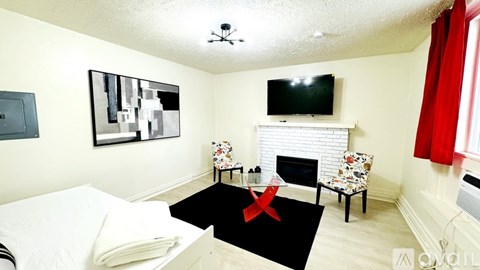 A bedroom with a bed, chair, and television.