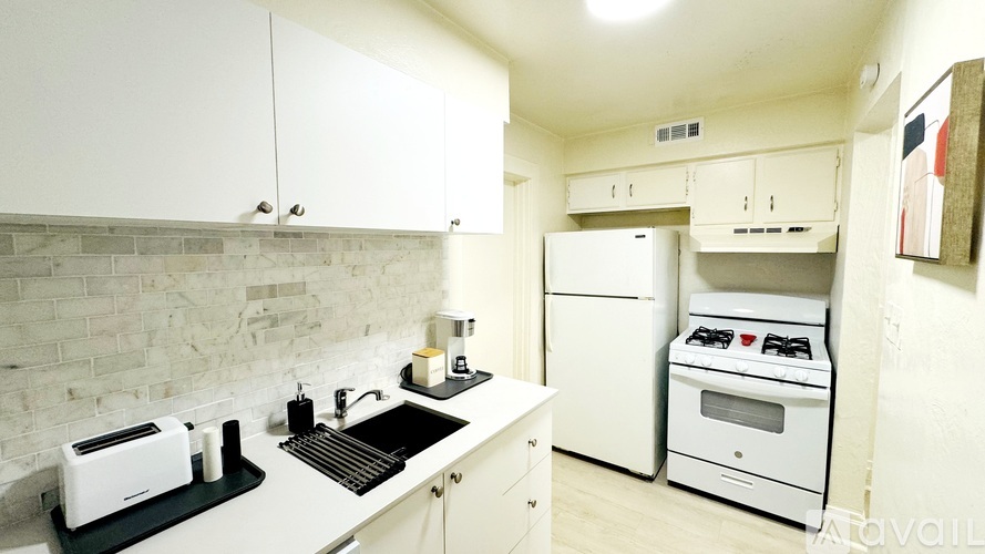 A kitchen with white cabinets and a white oven.