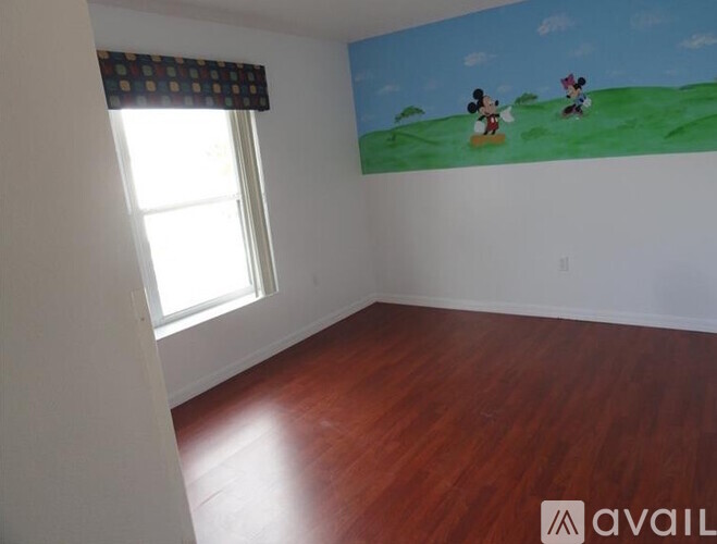 A room with a Mickey Mouse painting on the wall.