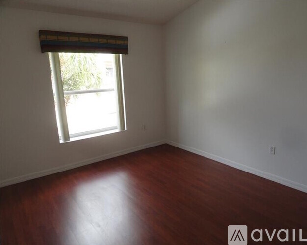 A room with a window and wooden floor.