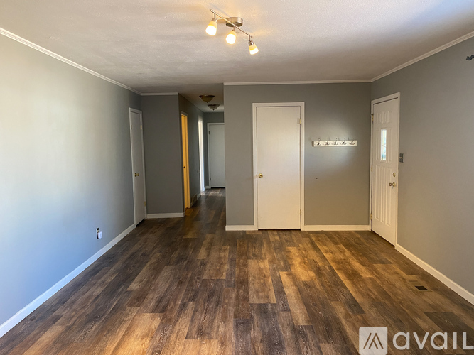 A room with wooden flooring and white walls.
