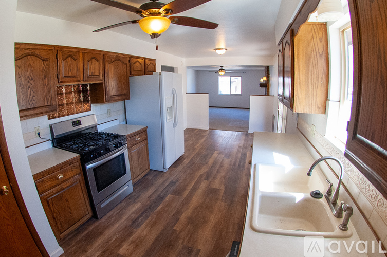 A kitchen with wooden cabinets and a white sink.