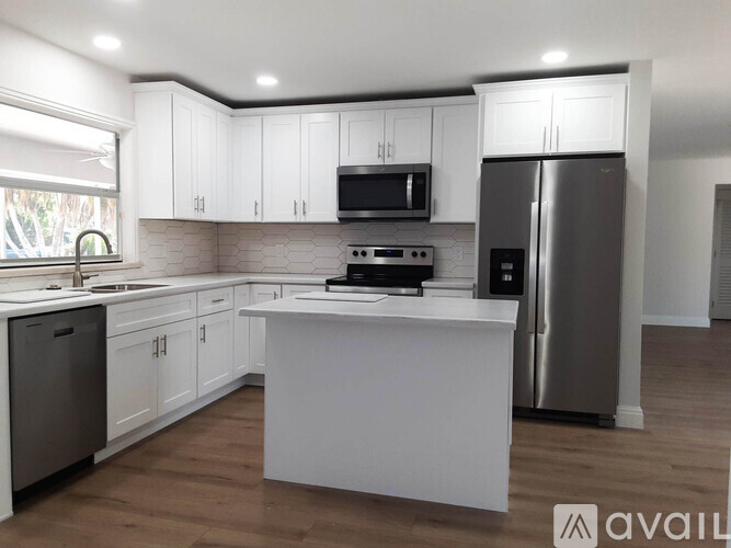 A kitchen with white cabinets and a central island.