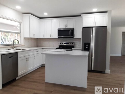A kitchen with white cabinets and a central island.