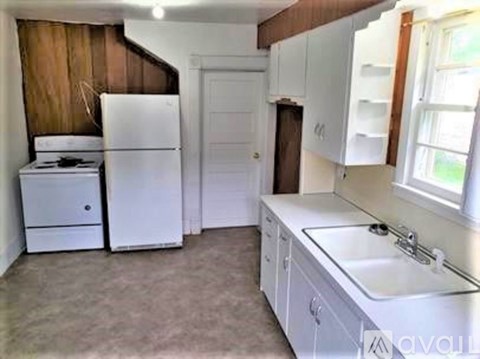 A kitchen with white appliances and cabinets.