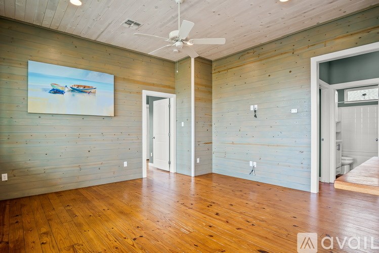 A room with wooden floors and a ceiling fan.