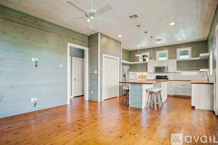 A kitchen with a wooden floor and white walls.