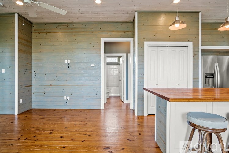 A kitchen with a bar stool in front of the counter.