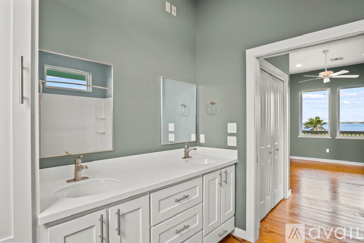A bathroom with a white sink and a large mirror.
