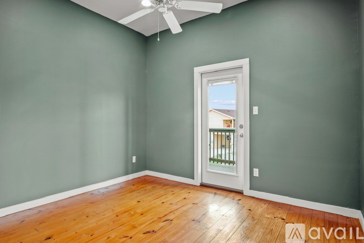 A room with a wooden floor and a ceiling fan.