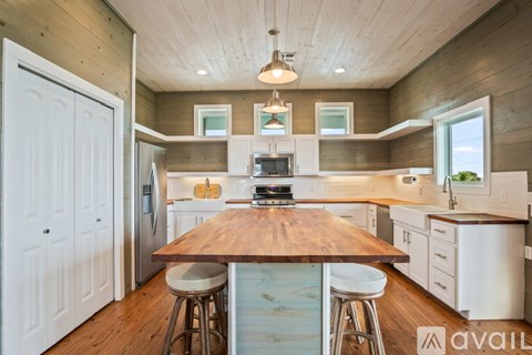 A kitchen with a wooden table and white cabinets.