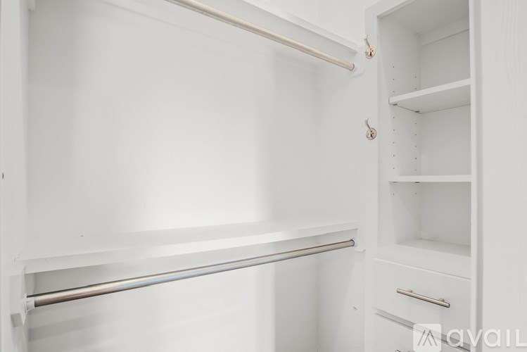 A white empty kitchen cabinet with a drawer and shelves.
