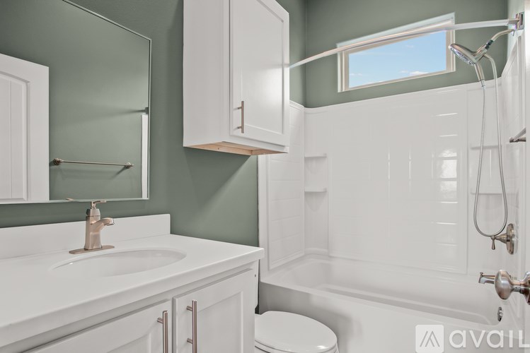 A bathroom with a white sink and a toilet.