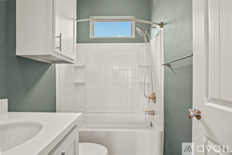 A white bathroom with a toilet, sink, and tub.