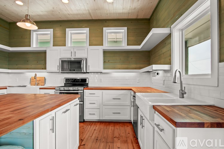 A kitchen with wooden floors and white cabinets.