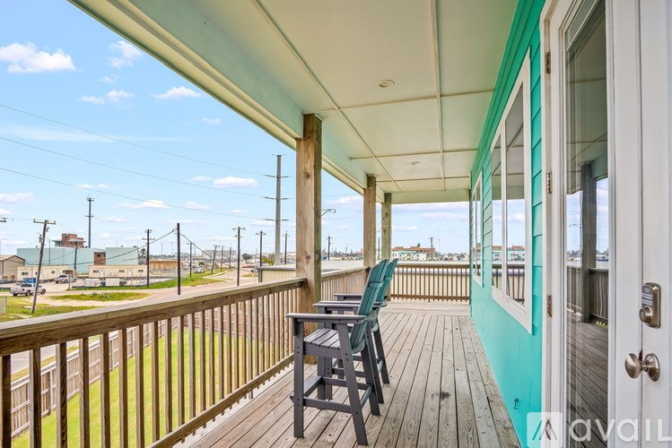 A balcony with a table and chairs overlooking a street.