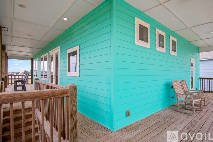 A bright blue house with a deck and chairs.
