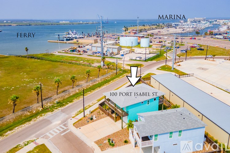 A ferry is docked at a port with a building that has the address 100 Port Isabel St.