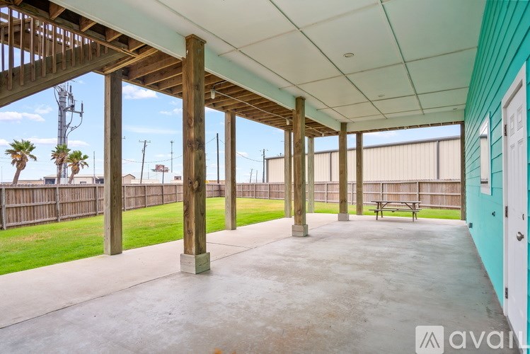 A long covered walkway with wooden pillars and a white ceiling.