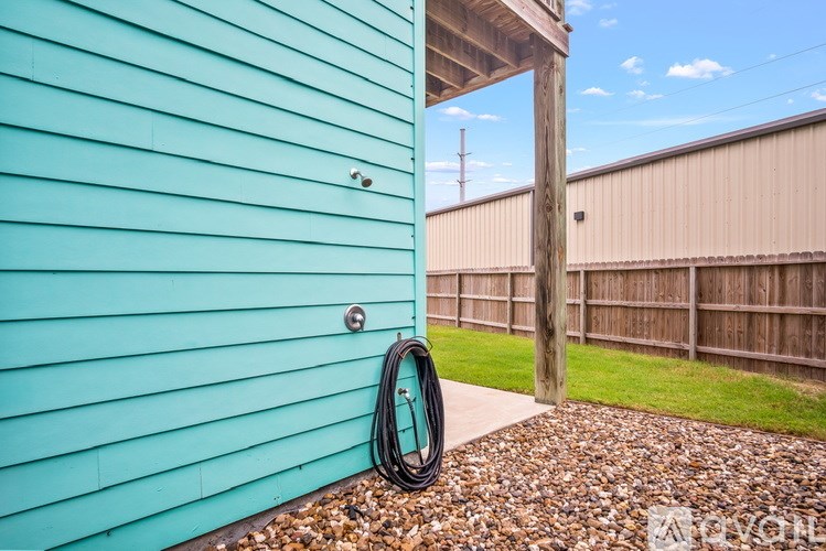 A blue house with a hose hanging on the wall.