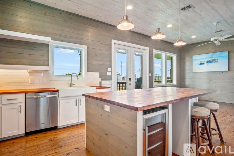 A kitchen with a wooden floor and white cabinets.