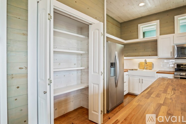 A kitchen with wooden floors and white appliances.
