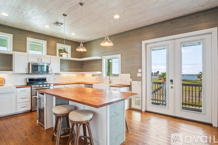A kitchen with a wooden island and bar stools.