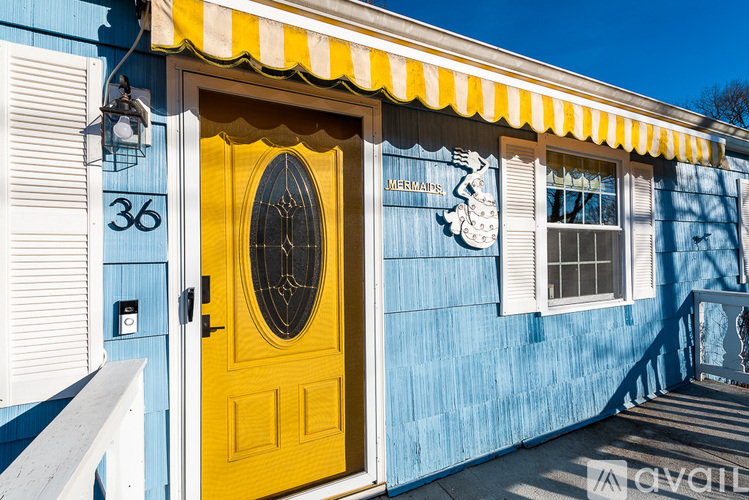 A yellow door with a window above it and a sign on the wall.