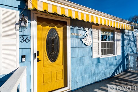 A yellow door with a window above it and a sign on the wall.