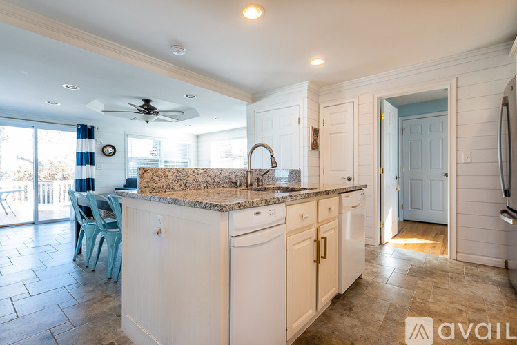 A kitchen with white cabinets and a granite countertop.