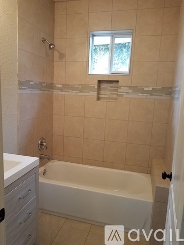 A bathroom with a tub and a window.