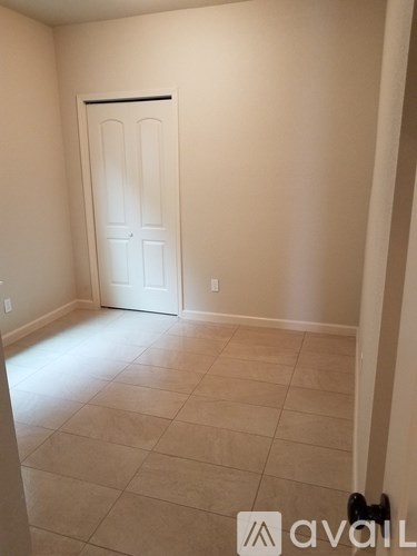 A room with a white door and tiled floor.