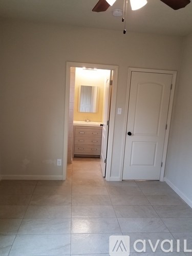 A room with a ceiling fan and a door leading to another room.