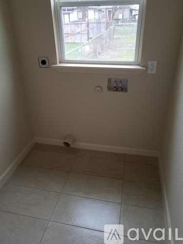 A room with a window and a tiled floor.